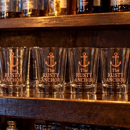 Custom bar shot glasses on a shelf